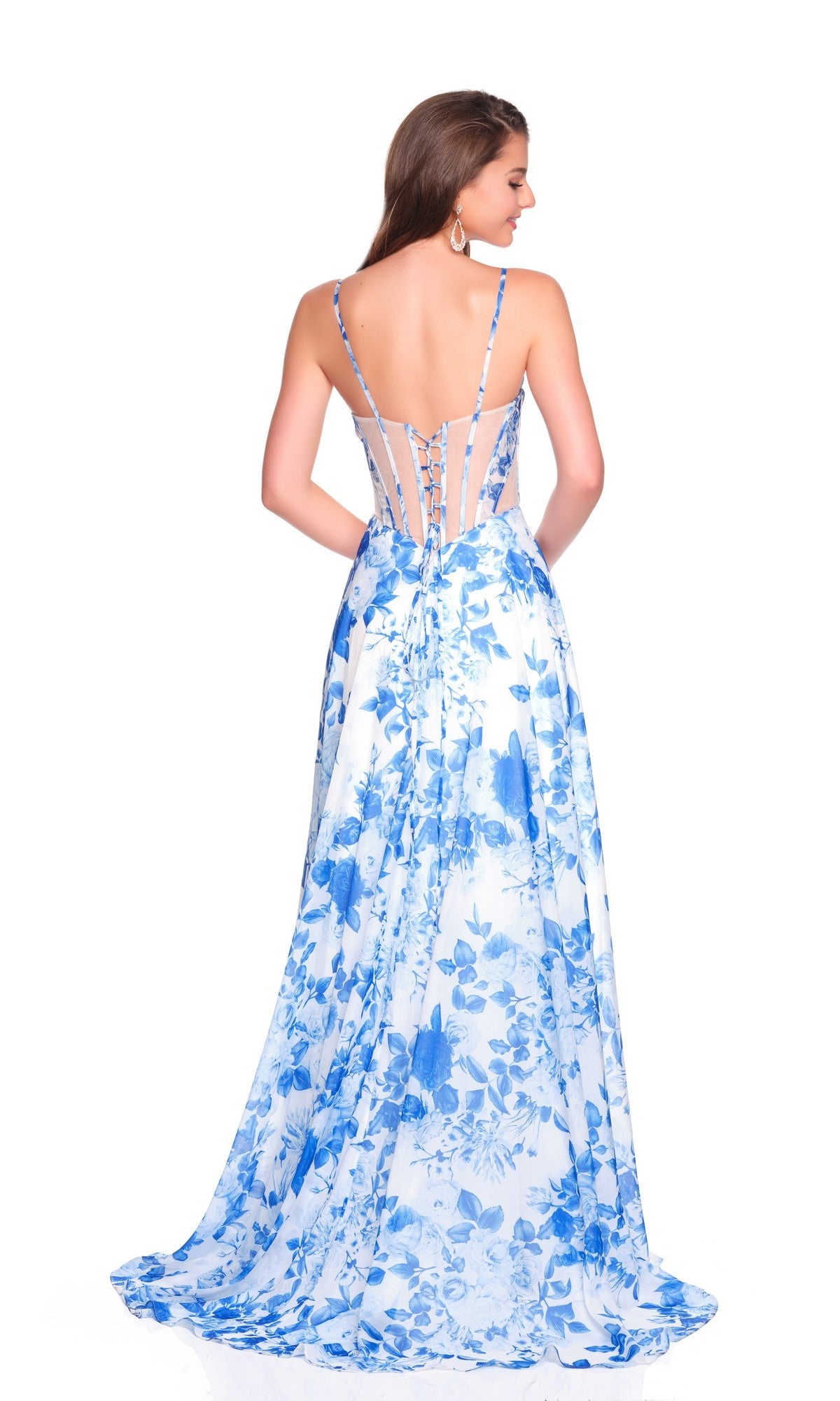 A woman stands facing away, wearing the Dave & Johnny 12188 blue floral prom dress featuring a strappy open back and corset bodice.